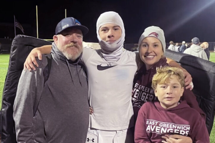 A family smiles together after a high school football game.