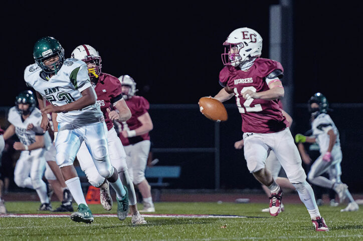 A football quarterback attempts to run the ball past an opponent.