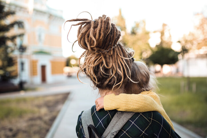 woman holding young girl while walking outside