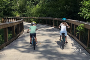 Two elementary school-aged children ride their bikes