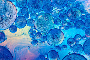 Clusters of overlapping bubble-like droplets in different sizes on a liquid surface.