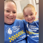 Mother and daughter smile together in matching Boston Children's t-shirts