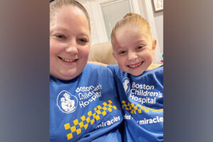 Mother and daughter smile together in matching Boston Children's t-shirts