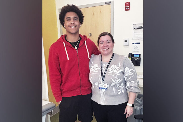 A teenage boy with his arm around his female doctor
