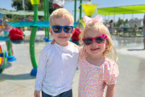 two young children smiling and wearing sunglasses