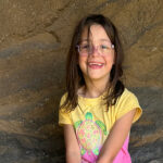 A 6-year-old girl smiles at the camera