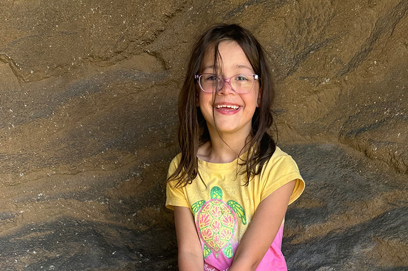 A 6-year-old girl smiles at the camera