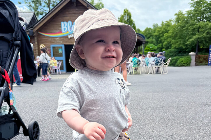 A young boy wearing a bucket hat smiles.