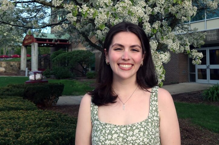 A young woman smiles outside Rhode Island College’s Unity Center.