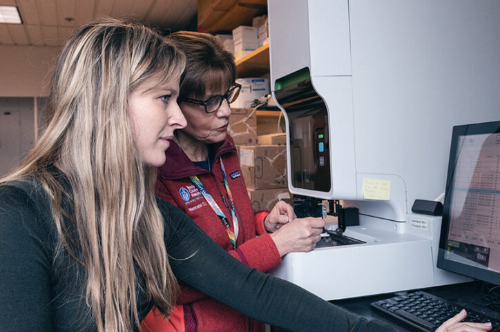 Doctors Patricia Davenport and Martha Sola-Visner in a lab, reviewing data on a computer screen.